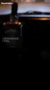 Conductor tomando whisky dentro de un vehículo en movimiento por la ruta