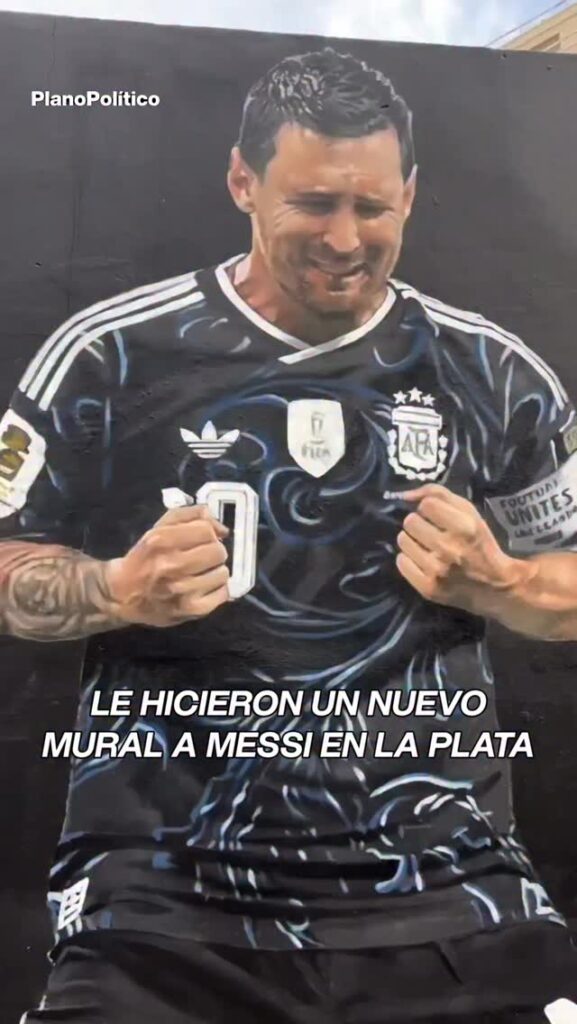 Mural callejero de Lionel Messi arrodillado con puños cerrados celebrando con camiseta argentina