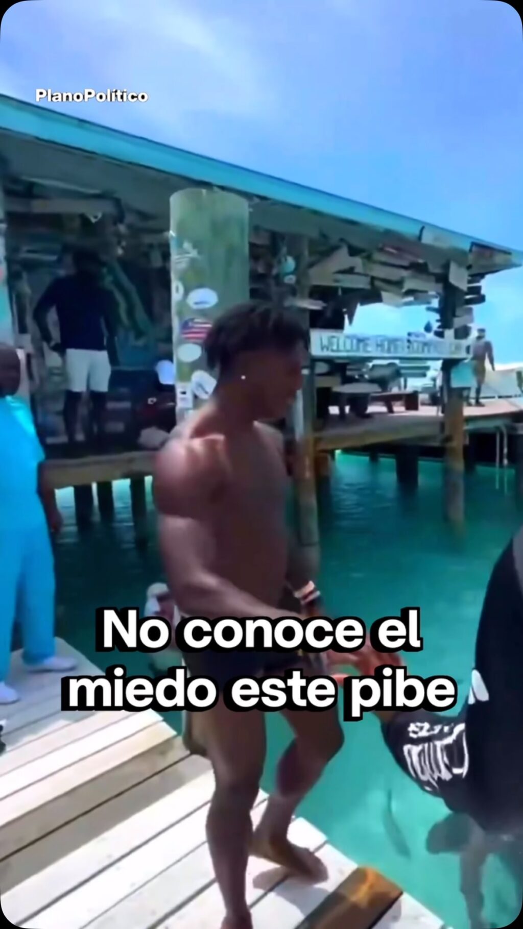 Streamer realizando acrobacias en el agua con tiburones nadando alrededor en las Bahamas