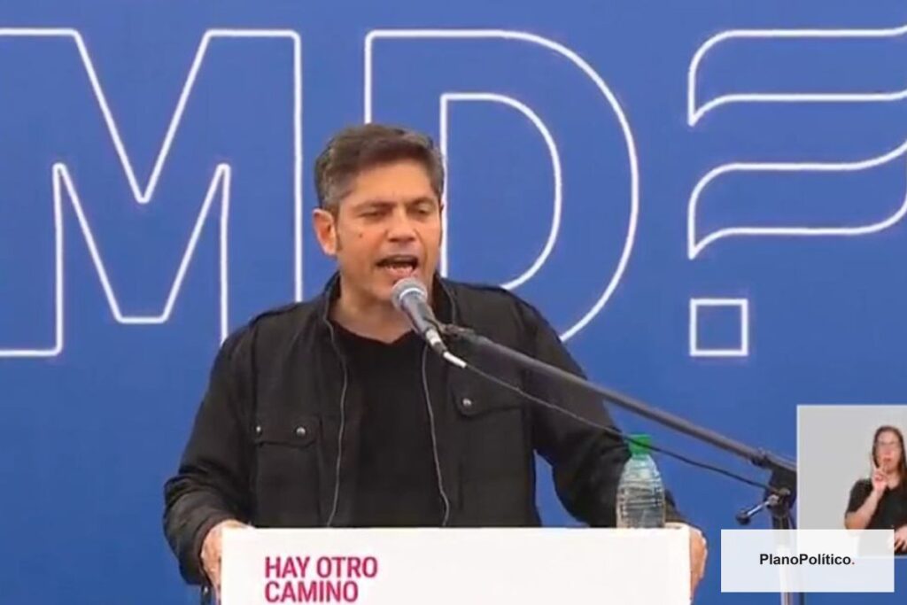 Axel Kicillof en evento político frente a banderas argentinas