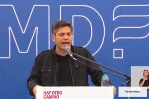 Axel Kicillof en evento político frente a banderas argentinas