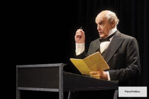 Actor interpretando a Domingo Faustino Sarmiento en escenario teatral