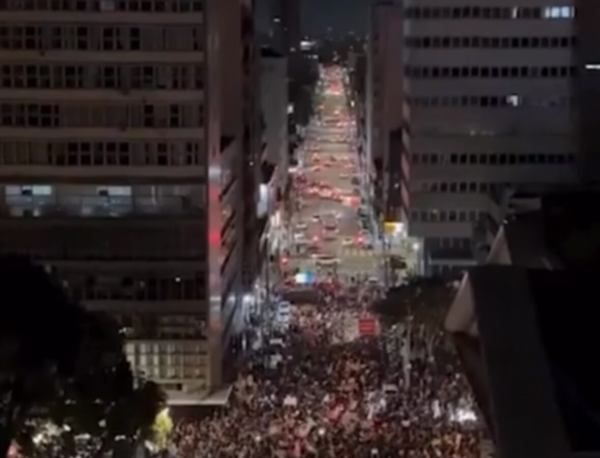 Manifestantes marchando en las calles de Curitiba durante protesta contra Flávio Bolsonaro