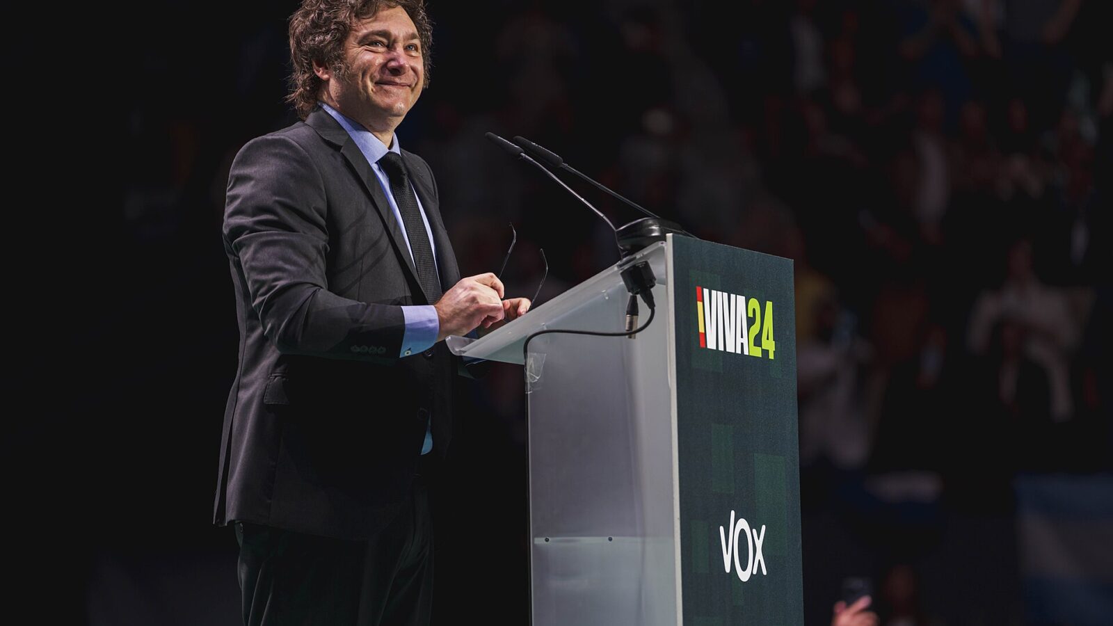Javier Milei hablando en un escenario con micrófono