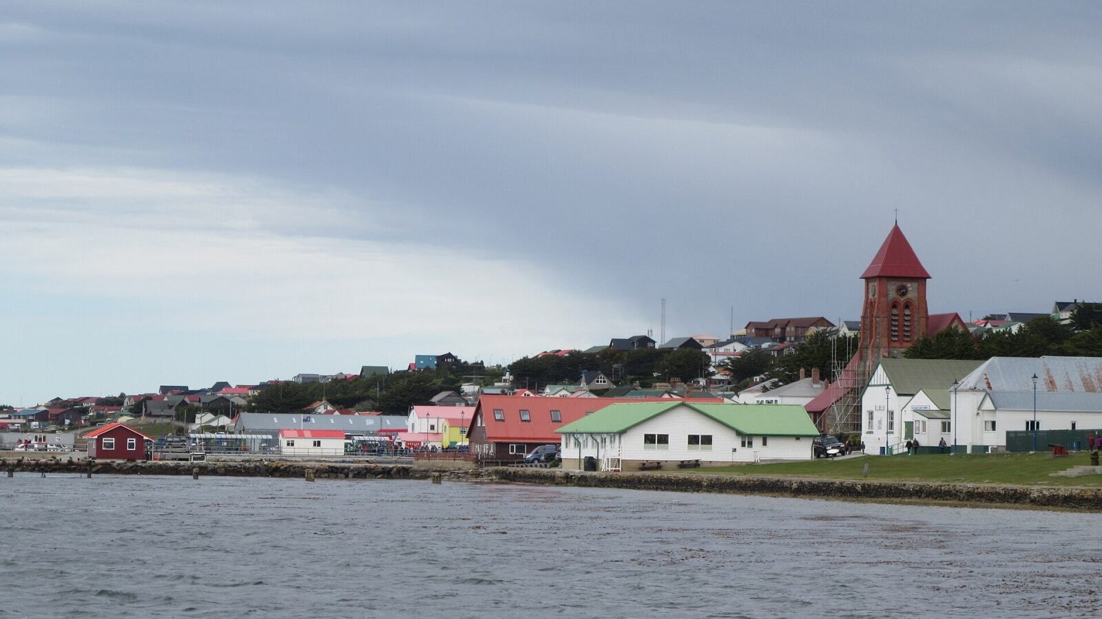 Costa y puerto de Stanley, capital de las islas Malvinas, con casas y una iglesia frente al agua