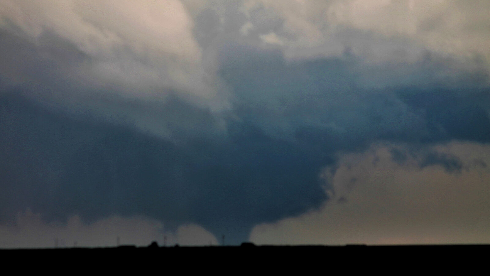 Tornado en una llanura bajo un cielo nublado